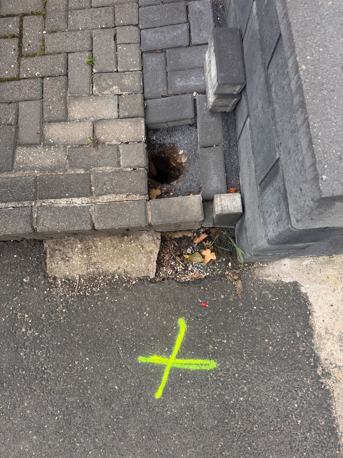 Markierung der georteten Leitung auf dem Gehweg vor dem Aufgraben in Kall